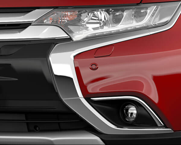 Close up image of the parking sensor on the front bumper of a red Mitsubishi SUV.