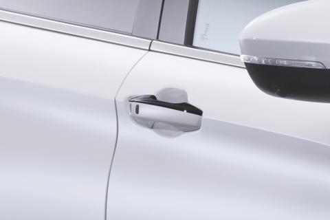 Black door handle cover on white Mitsubishi Eclipse Cross SUV. White and black mirror also in the shot.