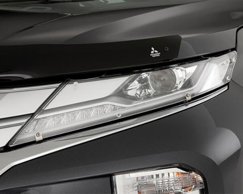 Acrylic headlight protectors attached to the headlamps of the Pajero Sport