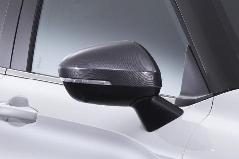 Wing mirror with a carbon look cover. Mounted on a white Mitsubishi Eclipse Cross with black frames around the window.