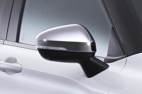 Wing mirror with a chrome cover. Mounted on a white Mitsubishi Eclipse Cross with black frames around the window.
