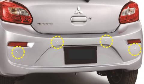 Four small circular parking assist sensors circled on the rear bumper of a Mitsubishi Mirage