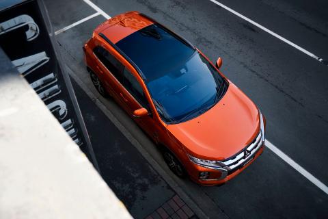 Looking down to an orange Mitsubishi ASX parked on side of the road