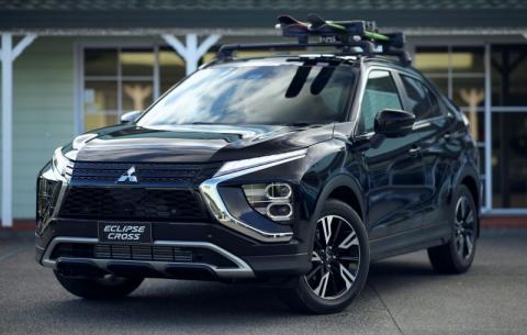A Mitsubishi Eclipse Cross with roof racks and adventure gear on top of it